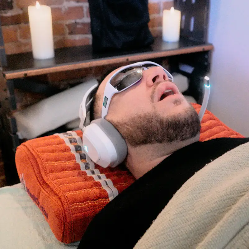 SoundSelf in session — candlelit space with LED glasses and headphones
